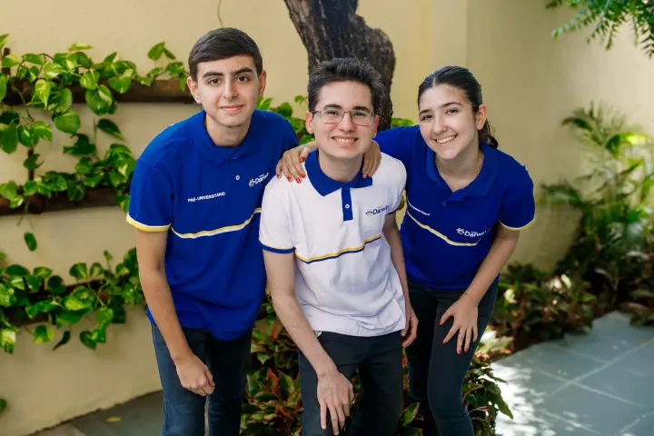 Três alunos do Ensino Médio do Darwin reunidos no jardim da escola